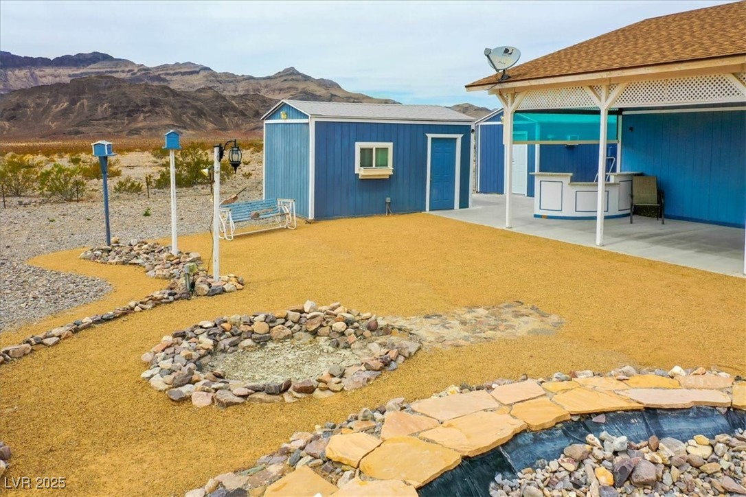 520 Burt Street Pahrump, NV 89060 - Photo 18 of 99 View of yard featuring an outdoor structure, a patio, and a mountain view