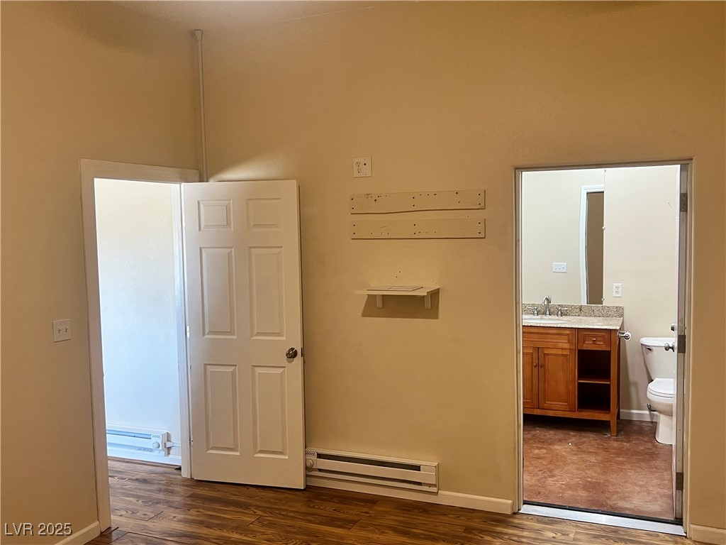 520 Burt Street Pahrump, NV 89060 - Photo 53 of 99 Corridor with baseboard heating, dark wood-type flooring, and a baseboard heating unit