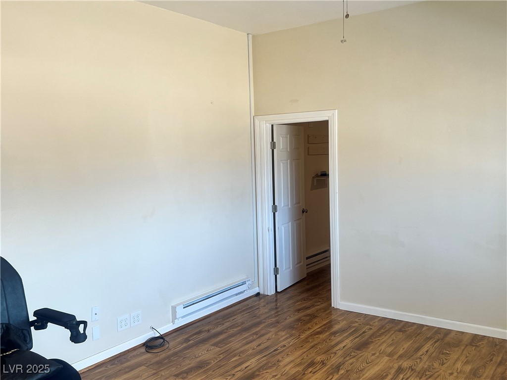 520 Burt Street Pahrump, NV 89060 - Photo 58 of 99 Empty room featuring dark wood-style floors and a baseboard heating unit