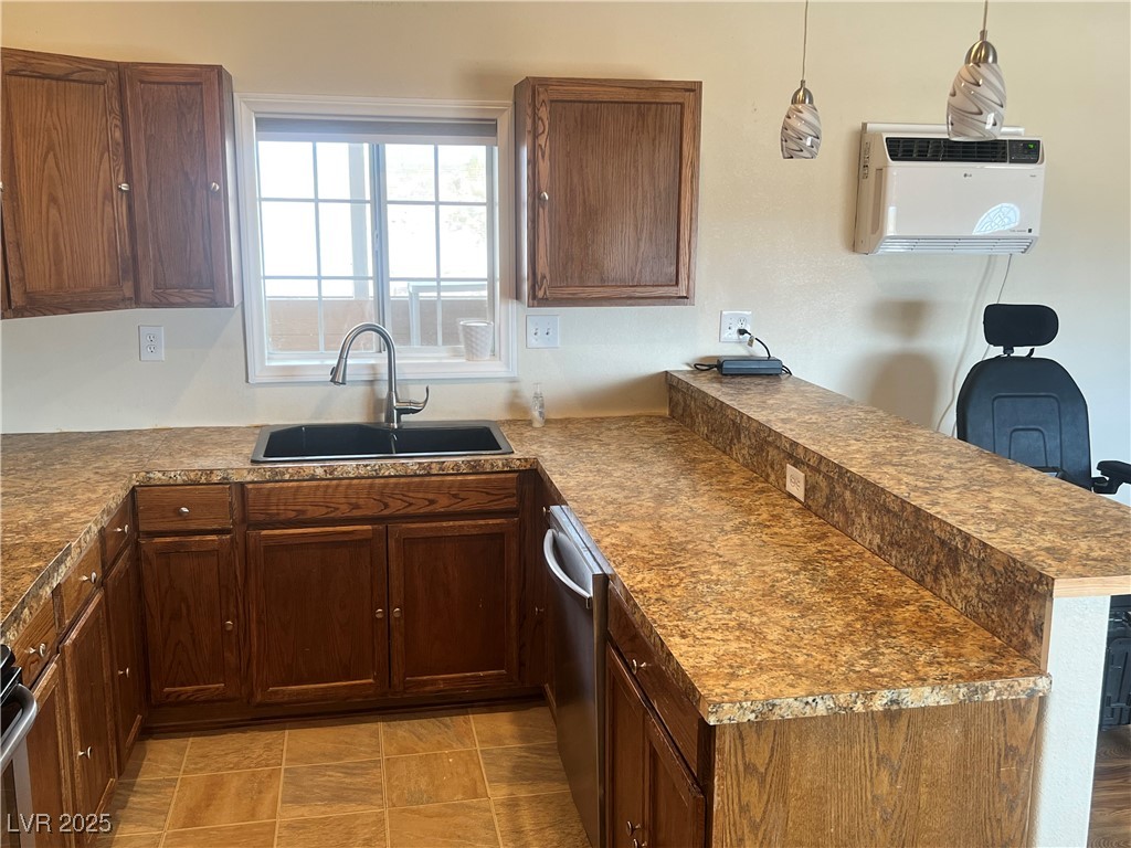 520 Burt Street Pahrump, NV 89060 - Photo 62 of 99 Kitchen featuring a peninsula, hanging light fixtures, dishwasher, dark countertops, and an AC wall unit
