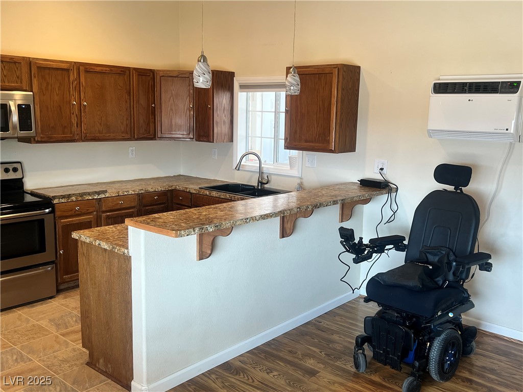 520 Burt Street Pahrump, NV 89060 - Photo 65 of 99 Kitchen with a breakfast bar, stainless steel appliances, pendant lighting, dark countertops, and a peninsula