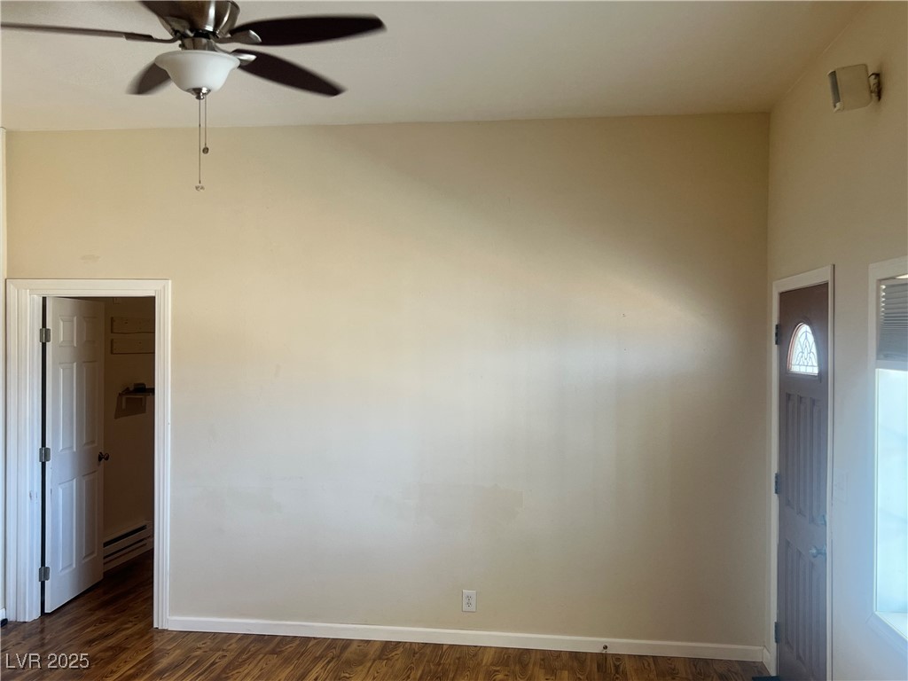 520 Burt Street Pahrump, NV 89060 - Photo 68 of 99 Unfurnished room featuring dark wood-type flooring, ceiling fan, and baseboard heating
