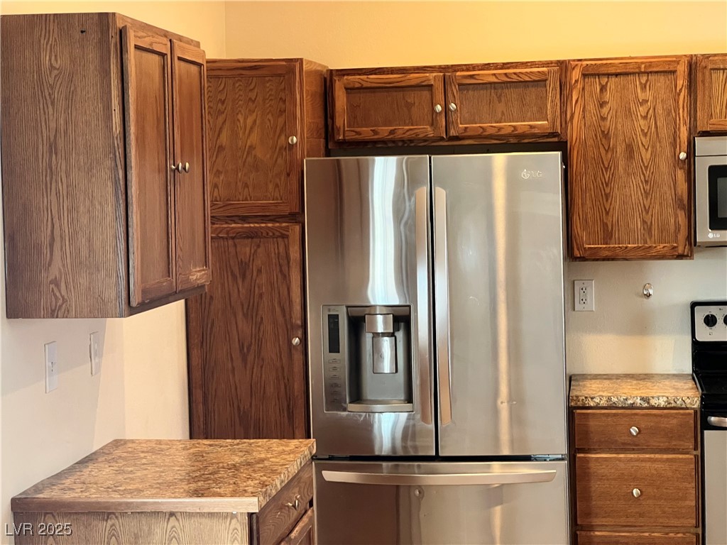 520 Burt Street Pahrump, NV 89060 - Photo 70 of 99 Kitchen featuring appliances with stainless steel finishes, brown cabinets, and light countertops