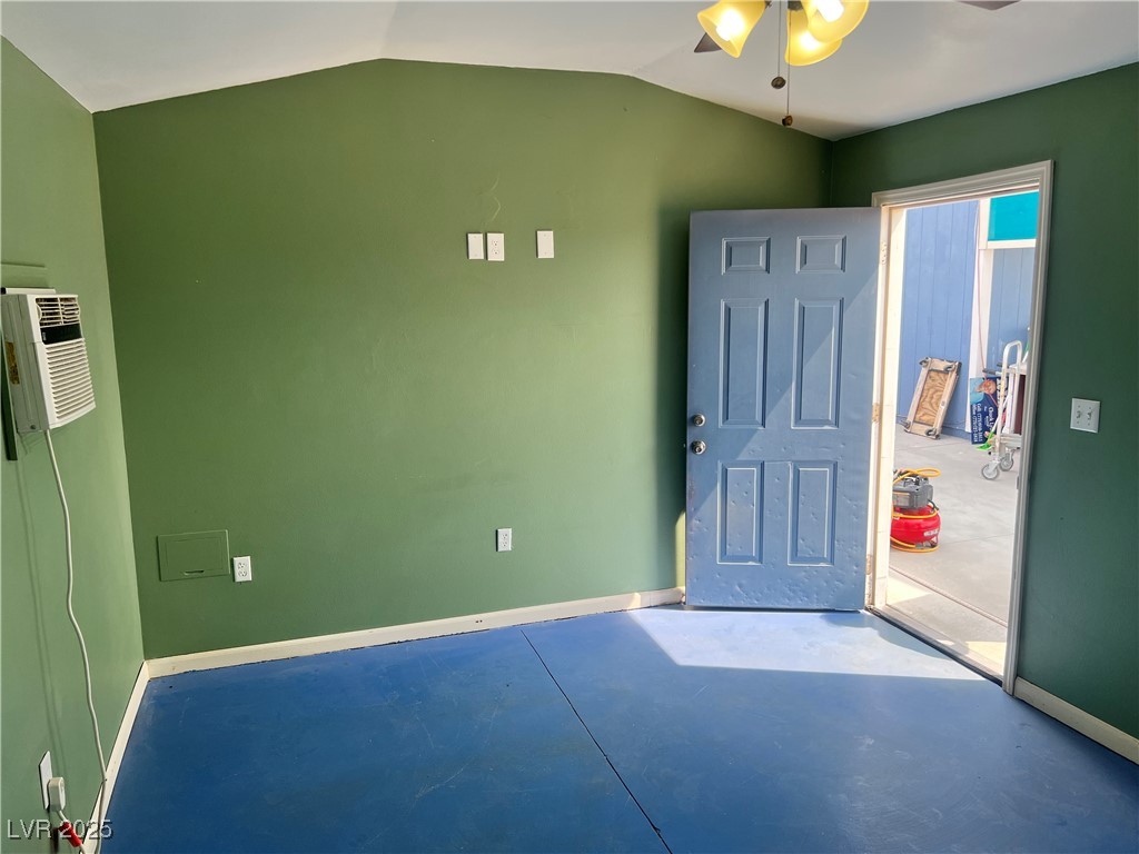 520 Burt Street Pahrump, NV 89060 - Photo 81 of 99 Empty room featuring concrete flooring, ceiling fan, vaulted ceiling, and a wall unit AC