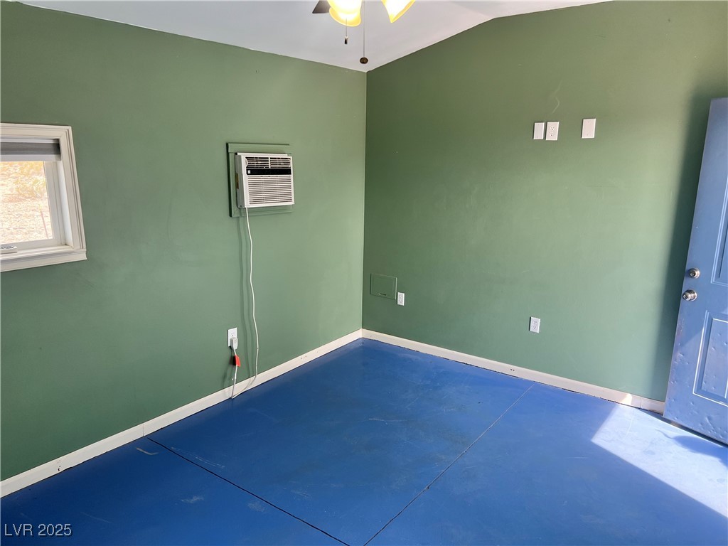 520 Burt Street Pahrump, NV 89060 - Photo 83 of 99 Spare room with finished concrete flooring, ceiling fan, an AC wall unit, and vaulted ceiling