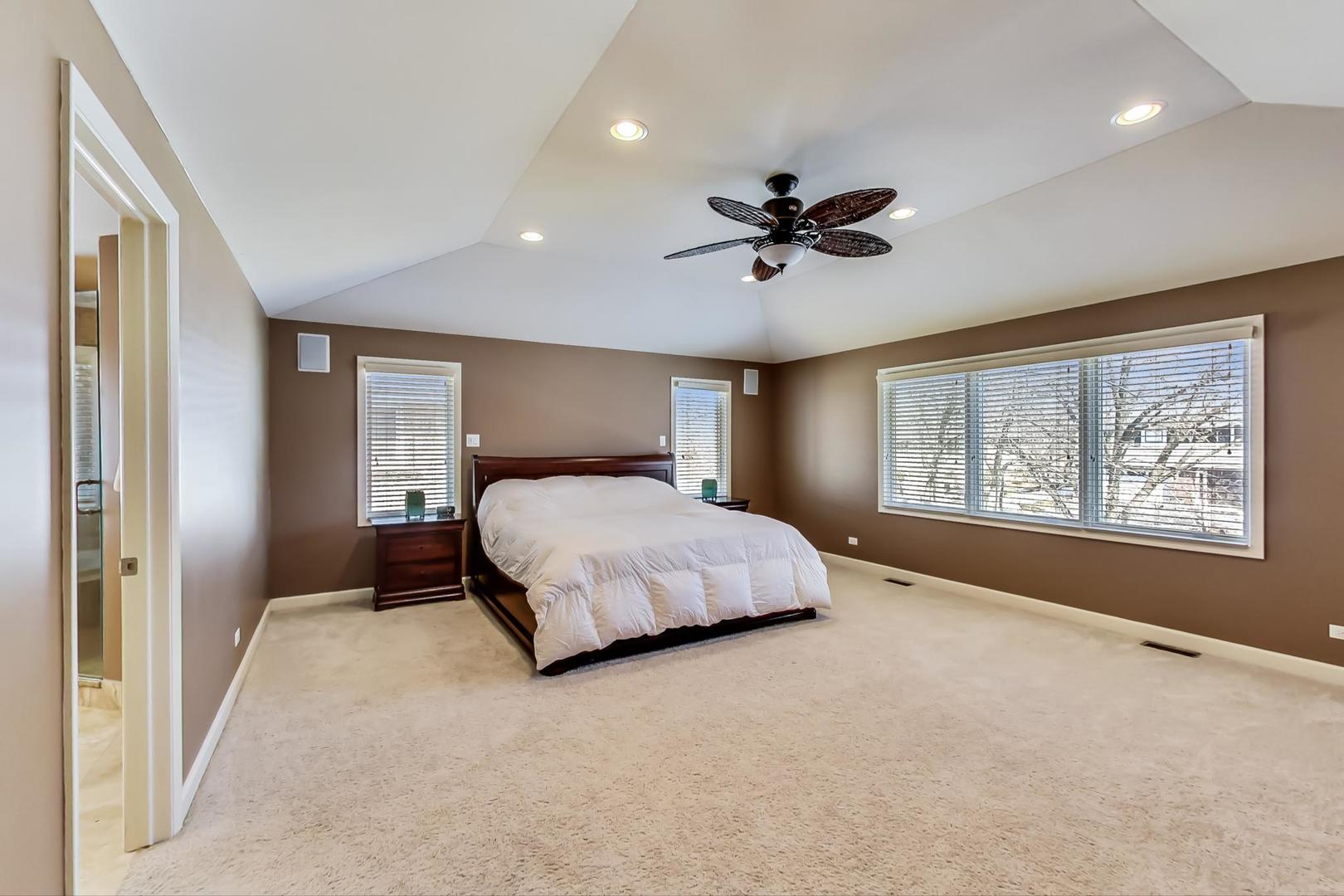 1846 Smith Road Northbrook, IL 60062 - Photo 23 of 58 a bedroom with a large bed and a chandelier