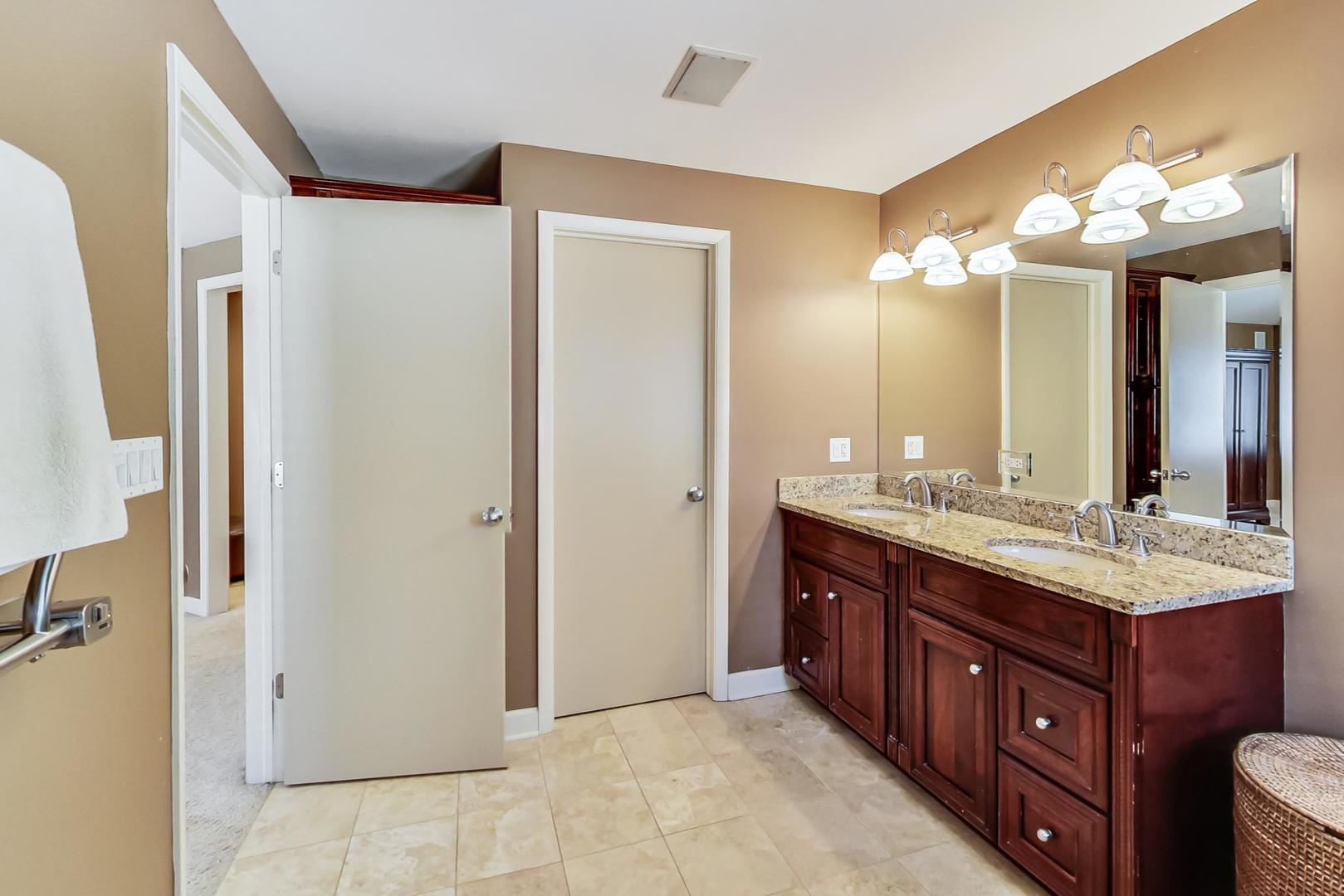 1846 Smith Road Northbrook, IL 60062 - Photo 28 of 58 a bathroom with a double vanity sink and a mirror
