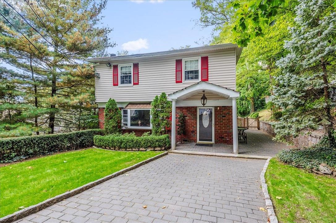 a view of a house with a yard and potted plants