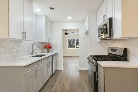 a kitchen with stainless steel appliances granite countertop a stove and a sink