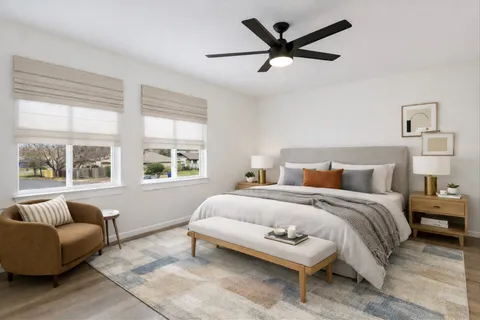 a bedroom with a bed a couch and a large window