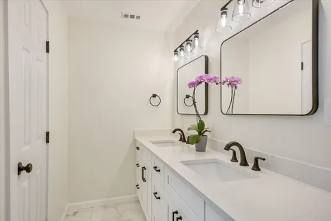 a bathroom with a sink vanity and mirror