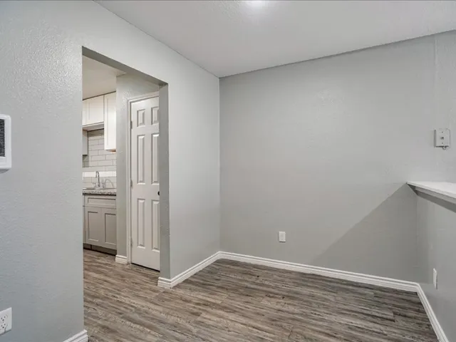 a view of an empty room with wooden floor and closet
