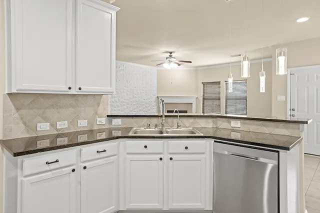 a kitchen with granite countertop white cabinets and a sink