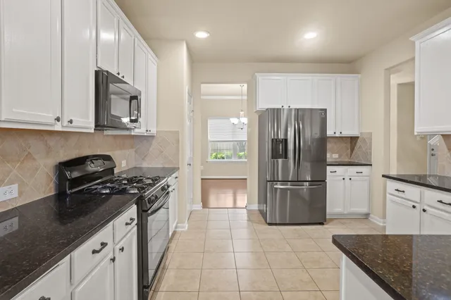 a kitchen with stainless steel appliances granite countertop a refrigerator stove and sink