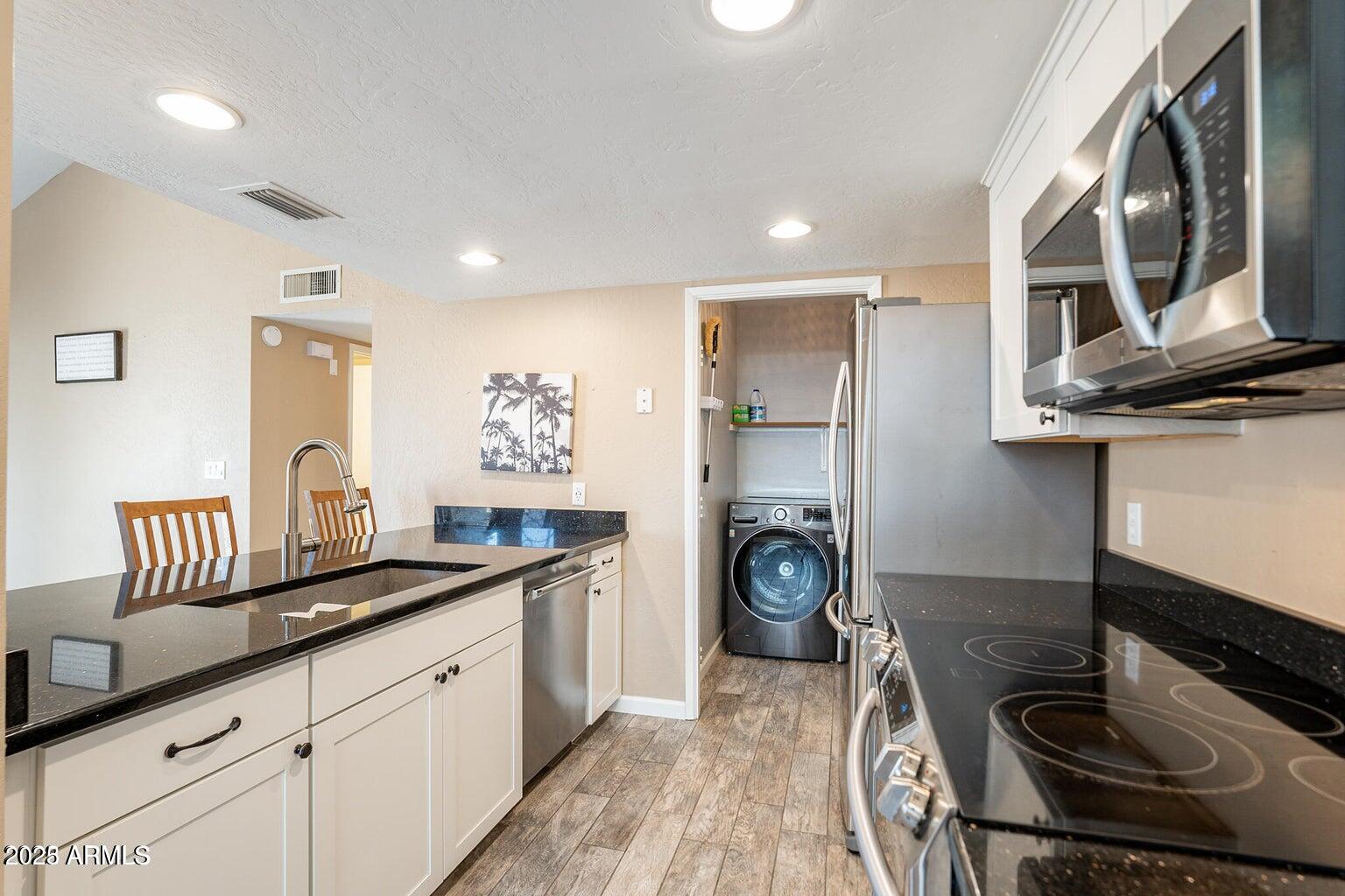 2019 West Lemon Tree Place, Unit 1115 Chandler, AZ 85224 - Photo 12 of 18 a kitchen with a sink and a stove top oven
