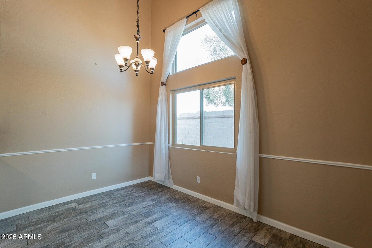 2019 West Lemon Tree Place, Unit 1115 Chandler, AZ 85224 - Photo 14 of 18 an empty room with wooden floor and windows