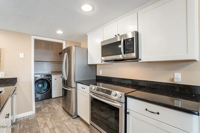 a kitchen with granite countertop wooden cabinets stove top oven and sink