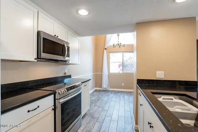 a kitchen with granite countertop a sink and wooden floor