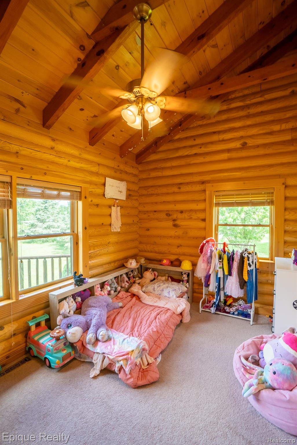 1966 Mayer Road Smiths Creek, MI 48074 - Photo 27 of 38 Room featuring natural wood log walls, a vaulted ceiling with exposed wood beams, and a ceiling fan with integrated lighting