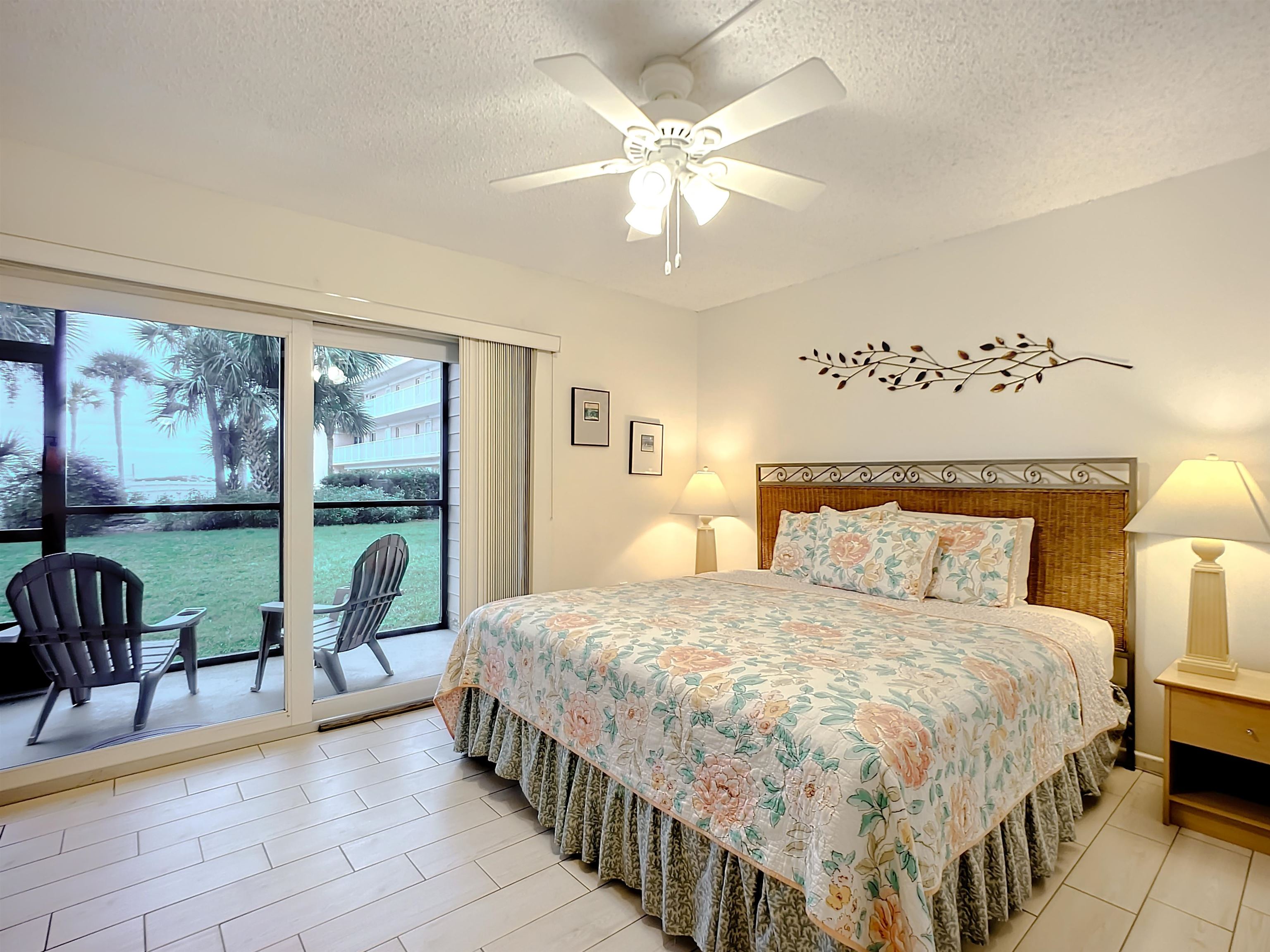 4 Ocean Trace Road, Unit 123 St. Augustine, FL 32080 - Photo 21 of 30 a bedroom with a bed a chandelier and a large window with outer view