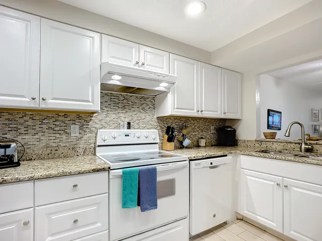 a kitchen with cabinets appliances a sink and a counter top space