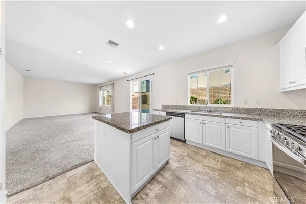 a kitchen with granite countertop sink and cabinets