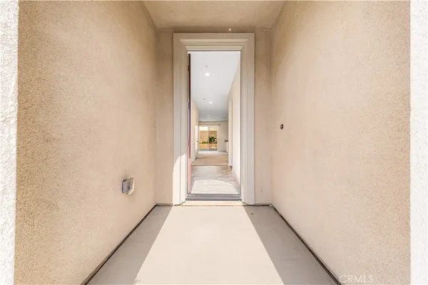 a view of a hallway with wooden floor and a bathroom