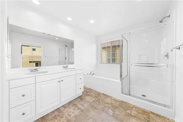 a spacious bathroom with double sink and shower