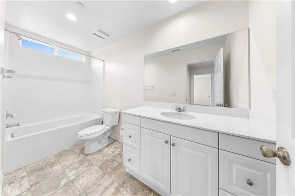 a bathroom with a granite countertop sink a toilet and a bathtub