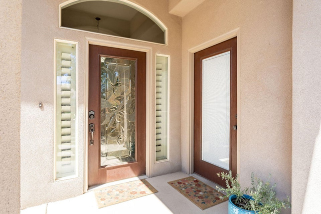 1609 East 10 S Street St. George, UT 84790 - Photo 45 of 68 Textured stucco exterior featuring a mahogany-finish entry door with decorative glass, an arched transom window, and two sidelight windows with integrated blinds