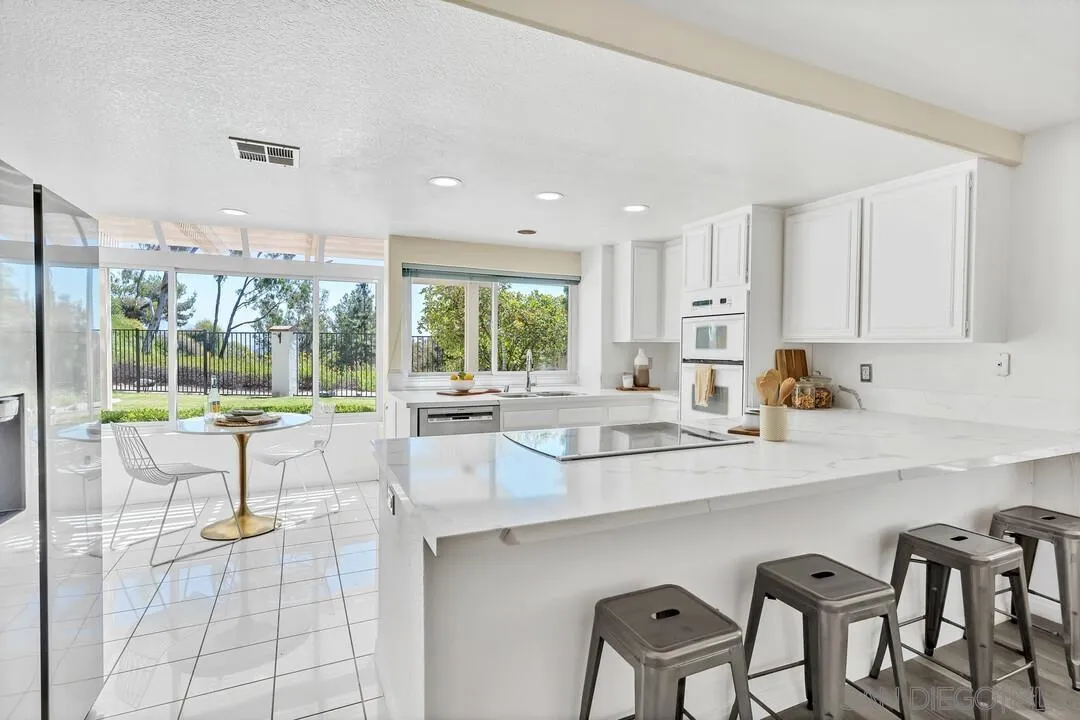 7967 Wing Span Drive San Diego, CA 92119 - Photo 11 of 45 a kitchen with granite countertop a table and chairs in it