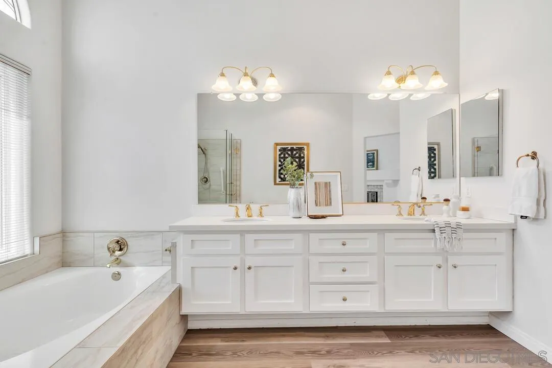 7967 Wing Span Drive San Diego, CA 92119 - Photo 28 of 45 a bathroom with a sink mirror and a bathtub with a chandelier