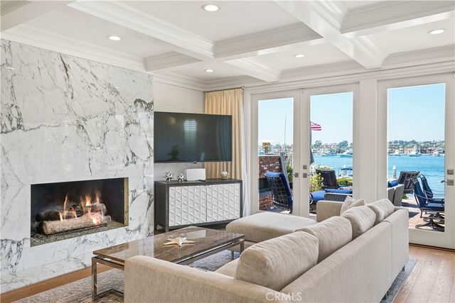 a living room with furniture a large window and wooden floor