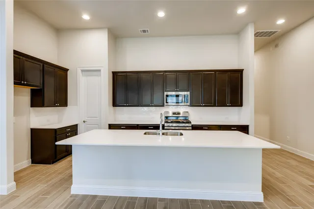 a view of living room with stainless steel appliances kitchen island sink and stove