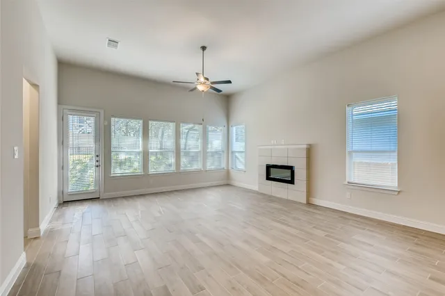 a view of empty room with wooden floor and fireplace