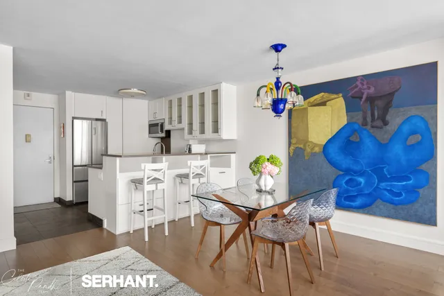 a living room with dining table and a chandelier