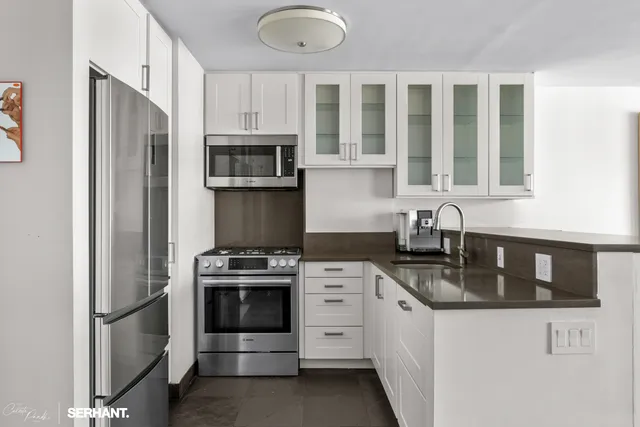 a kitchen with stainless steel appliances granite countertop a stove microwave and refrigerator
