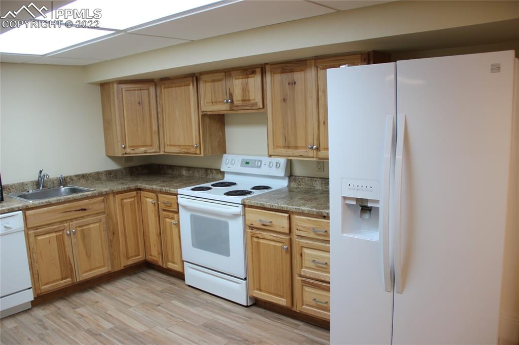 749 B 9th Street Calhan, CO 80808 - Photo 32 of 46 a kitchen with granite countertop a refrigerator sink and cabinets