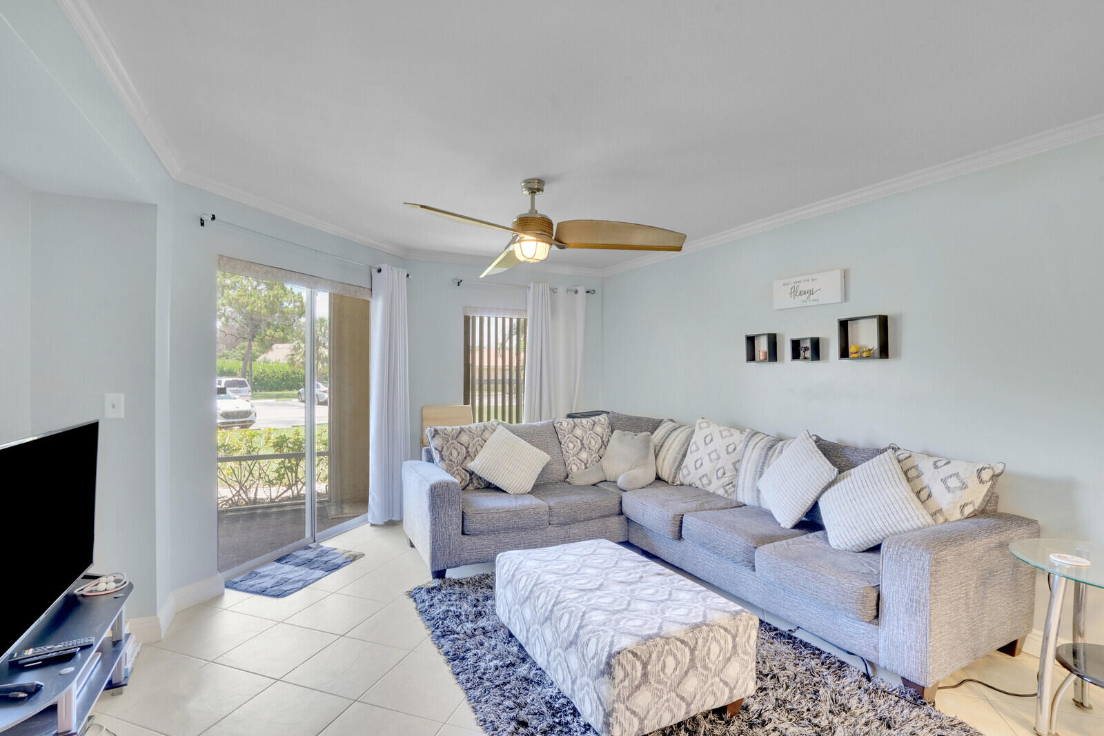 4855 Via Palm Lakes, Unit 902 West Palm Beach, FL 33417 - Photo 11 of 24 a living room with furniture and a flat screen tv