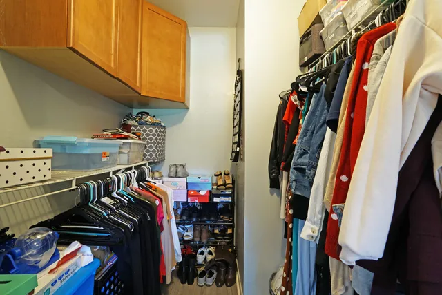 a view of walk in closet with clothes and shoes