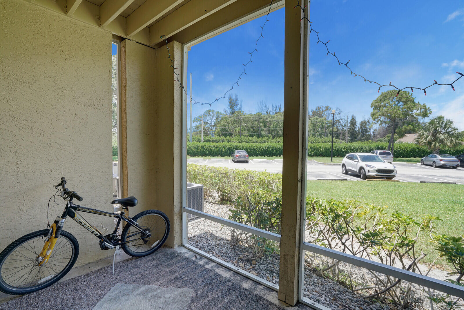 4855 Via Palm Lakes, Unit 902 West Palm Beach, FL 33417 - Photo 20 of 24 a view of a porch with chairs and a yard