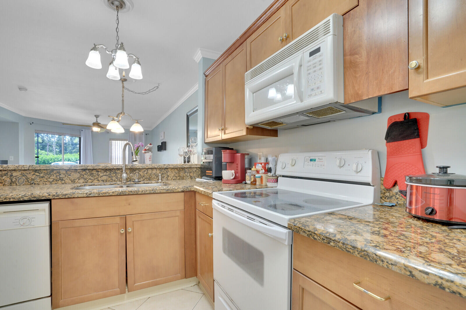 4855 Via Palm Lakes, Unit 902 West Palm Beach, FL 33417 - Photo 4 of 24 a kitchen with stainless steel appliances granite countertop a sink dishwasher and white cabinets with wooden floor