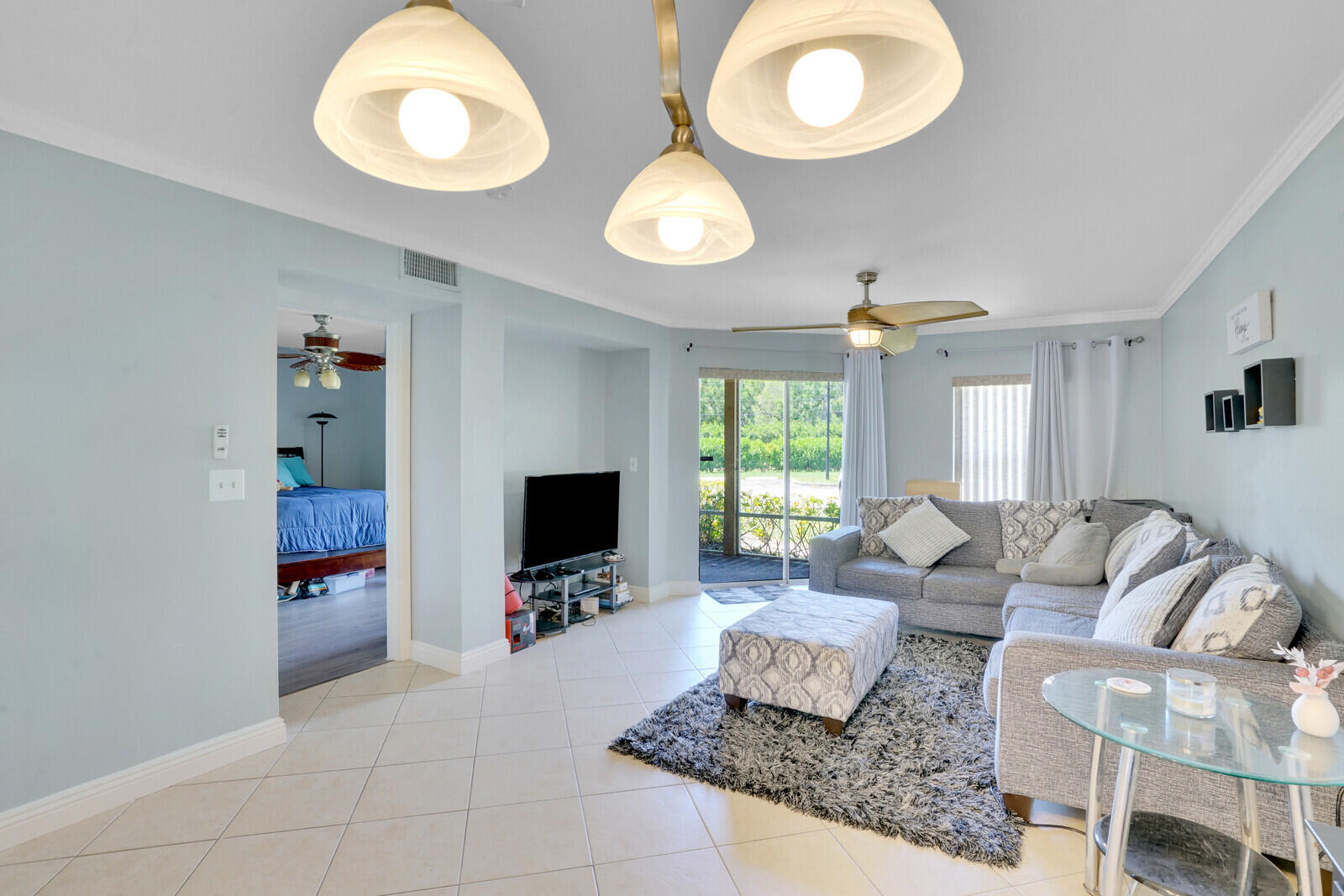 4855 Via Palm Lakes, Unit 902 West Palm Beach, FL 33417 - Photo 8 of 24 a living room with furniture and a flat screen tv