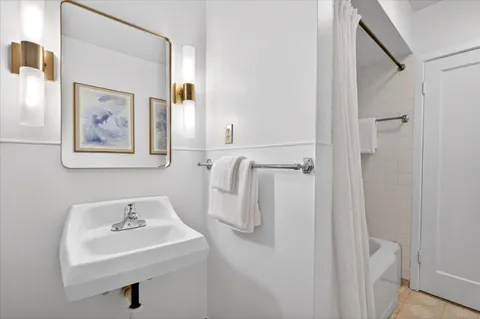 a bathroom with a sink and mirror with toilet