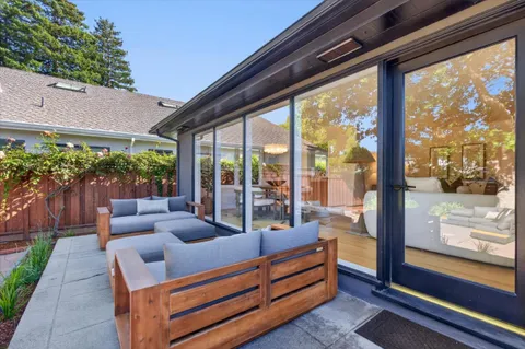 a living room with patio furniture and garden view