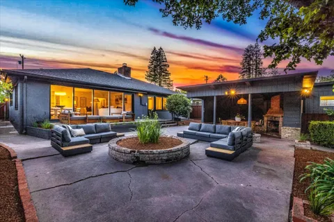 a living room with patio furniture and a potted plant