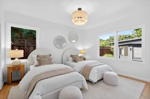 a bedroom with two beds and a large window