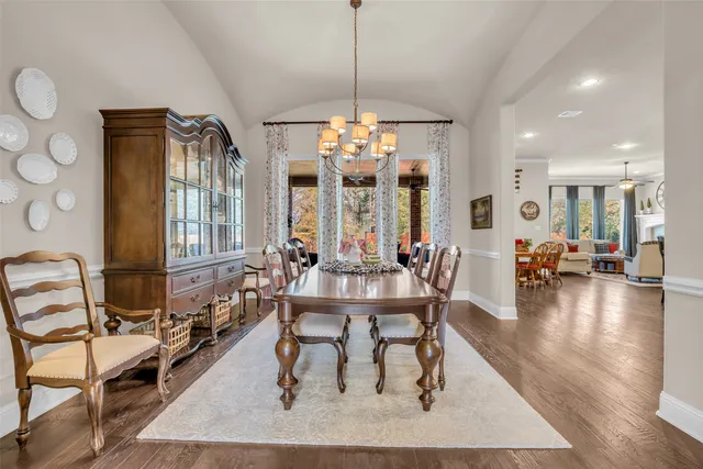 a view of a dining room and livingroom with furniture wooden floor a chandelier