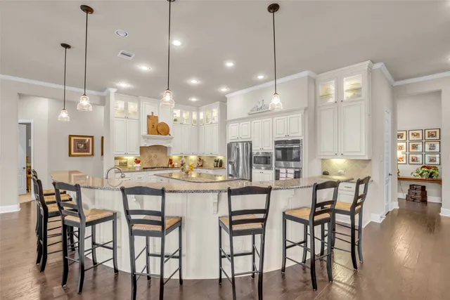 a large kitchen with stainless steel appliances kitchen island granite countertop a sink and cabinets