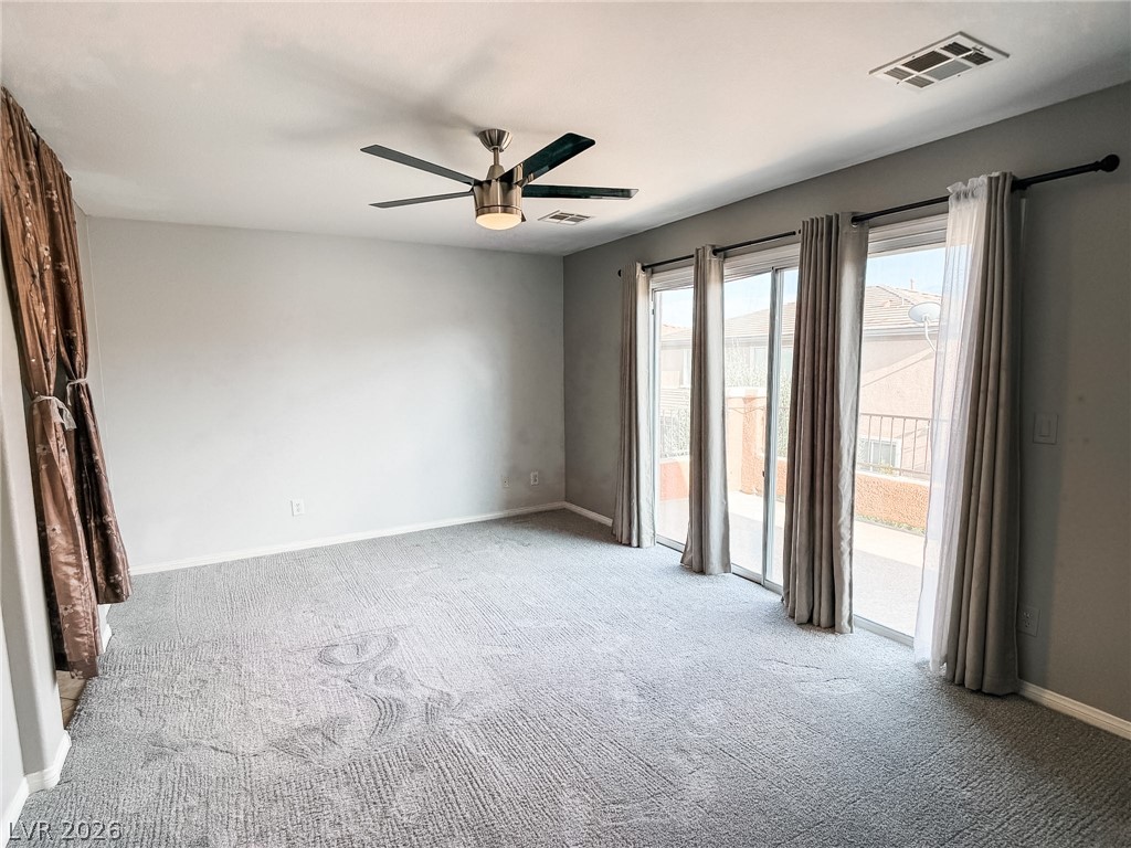 8683 Moreno Mountain Avenue Las Vegas, NV 89178 - Photo 17 of 26 A spacious room offers comfortable carpeted flooring and sliding glass doors that open to the outside.